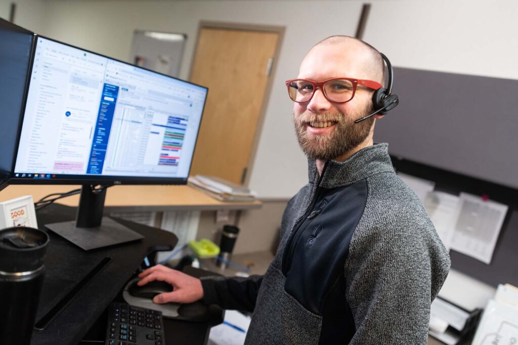 customer service employee smiling while working at a computer